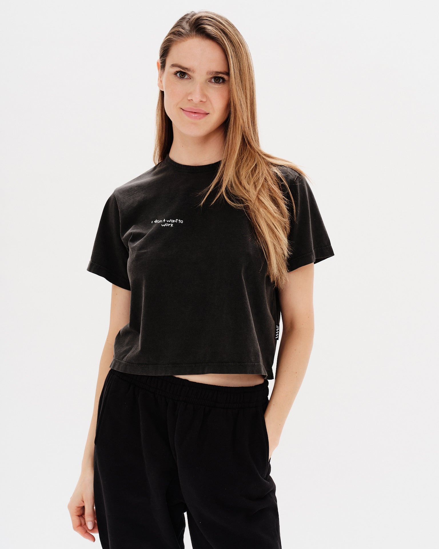 Woman wearing a black t-shirt with an I don't want to work embroidery