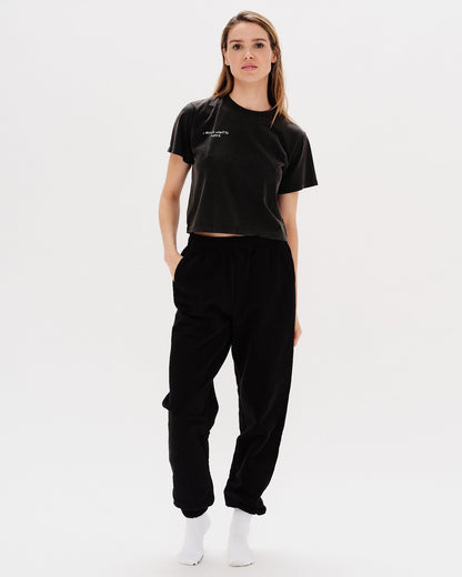 Woman wearing a black t-shirt with an I don't want to work embroidery