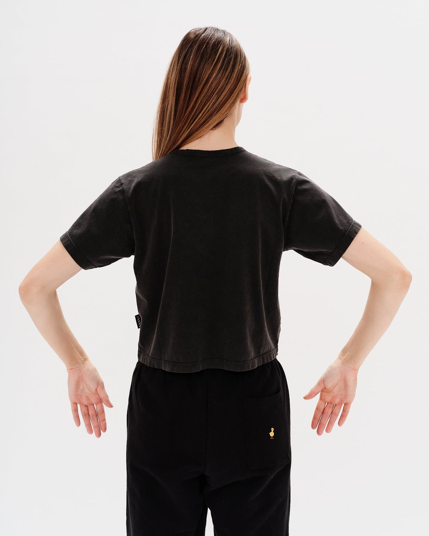 Woman wearing a black t-shirt with an I don't want to work embroidery
