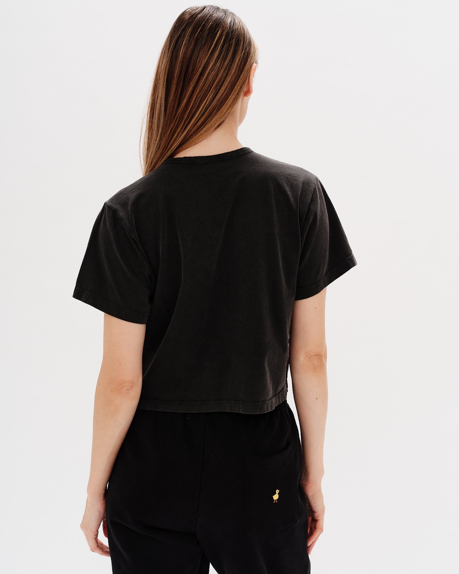 Woman wearing a black t-shirt with an I don't want to work embroidery