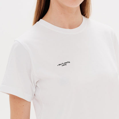Woman wearing a white t-shirt with an I don't want to work embroidery