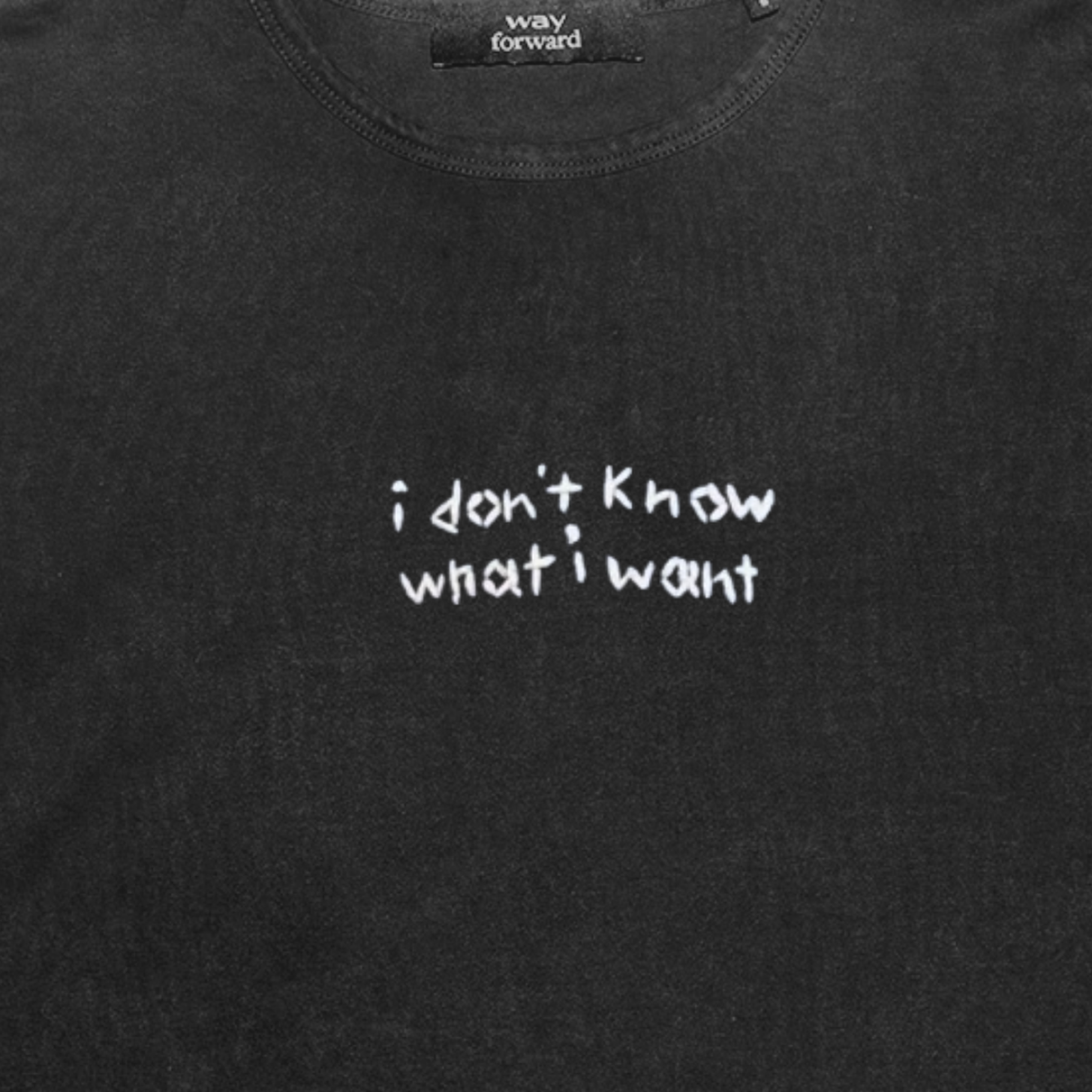 Black long sleeve crop tee with white embroidery text 'I don't know what I want' on the chest area.