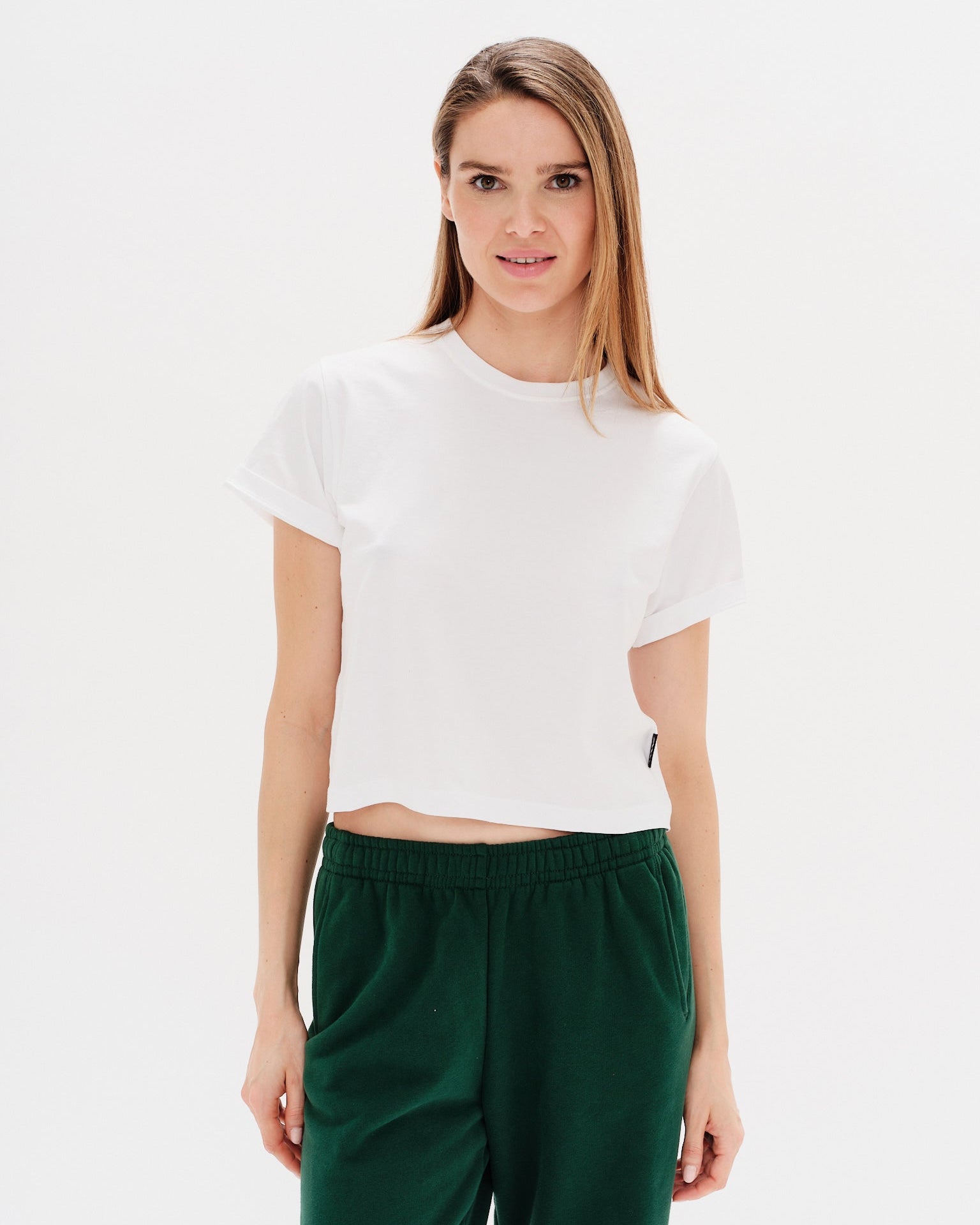 Woman wearing a white t-shirt and green pants