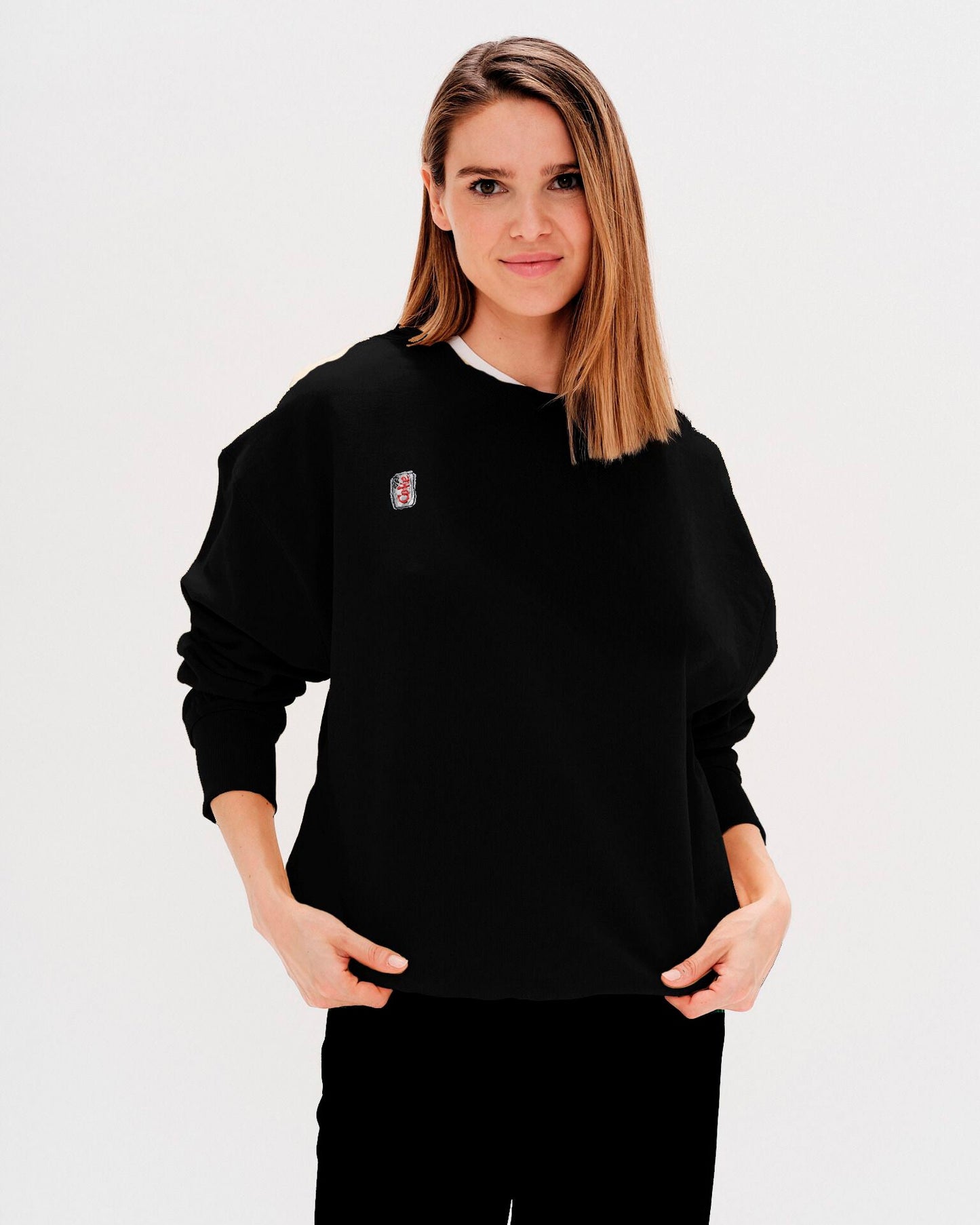 Woman wearing a black sweatshirt with a diet coke embroidery