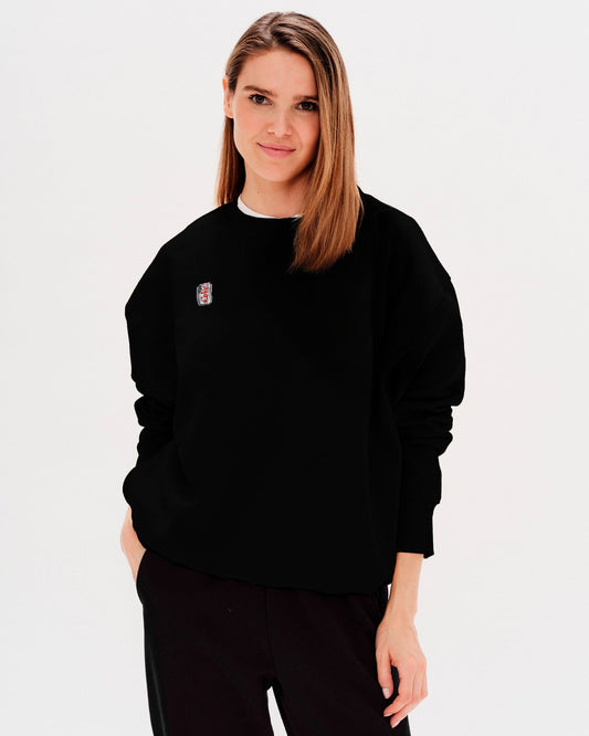 Woman wearing a black sweatshirt with a diet coke embroidery
