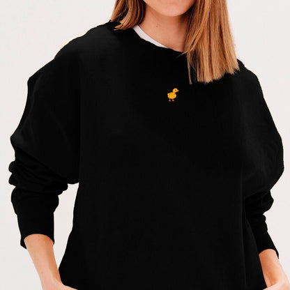 Woman wearing a black sweatshirt with a duck embroidery