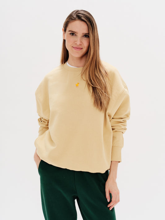 Woman wearing a yellow sweatshirt with a duck embroidery