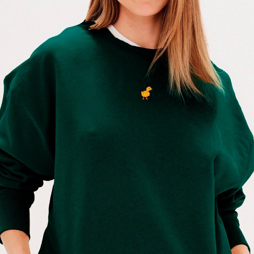 Woman wearing a green sweatshirt with a duck embroidery