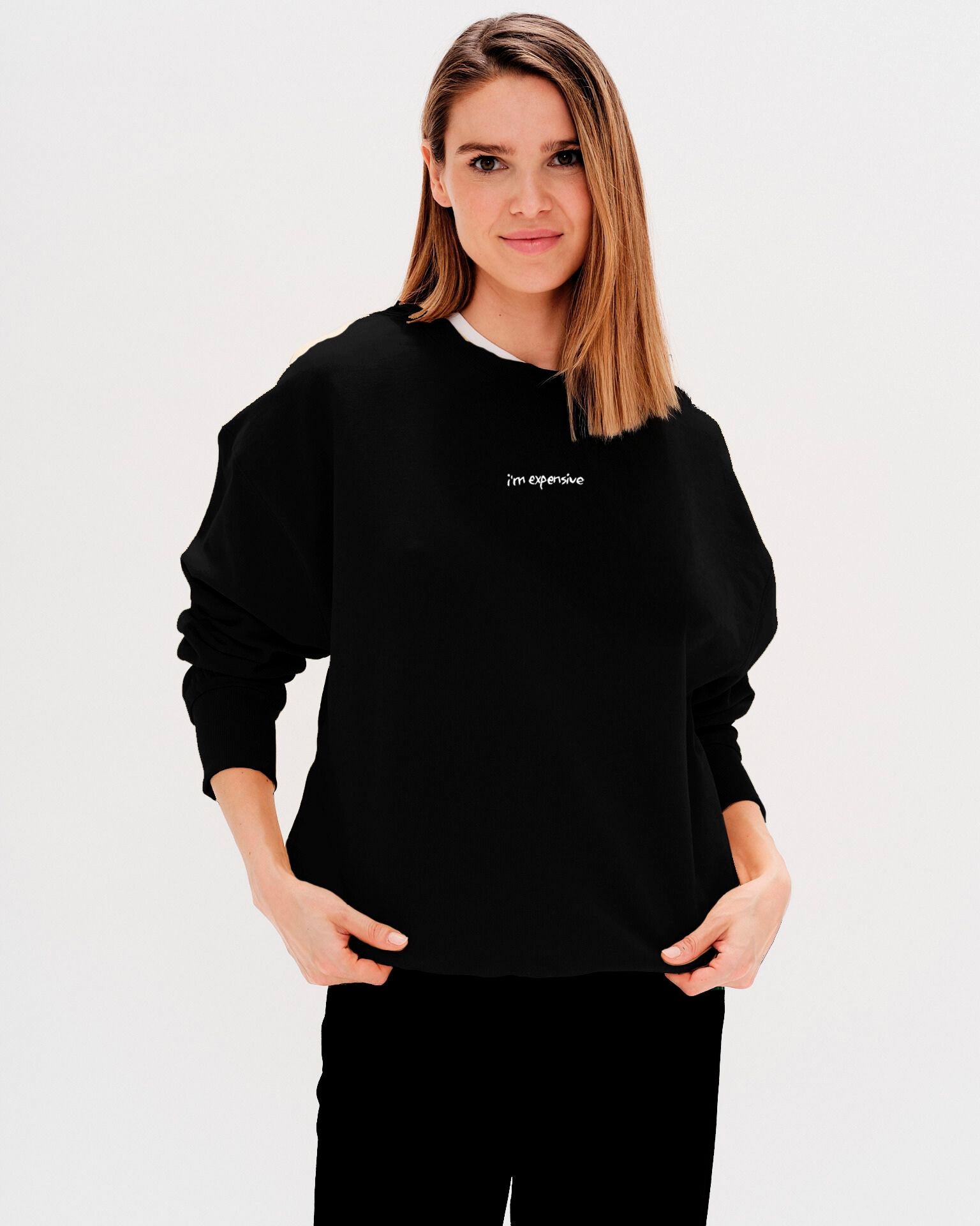 Woman wearing a black sweatshirt with an 'I'm expensive' embroidery