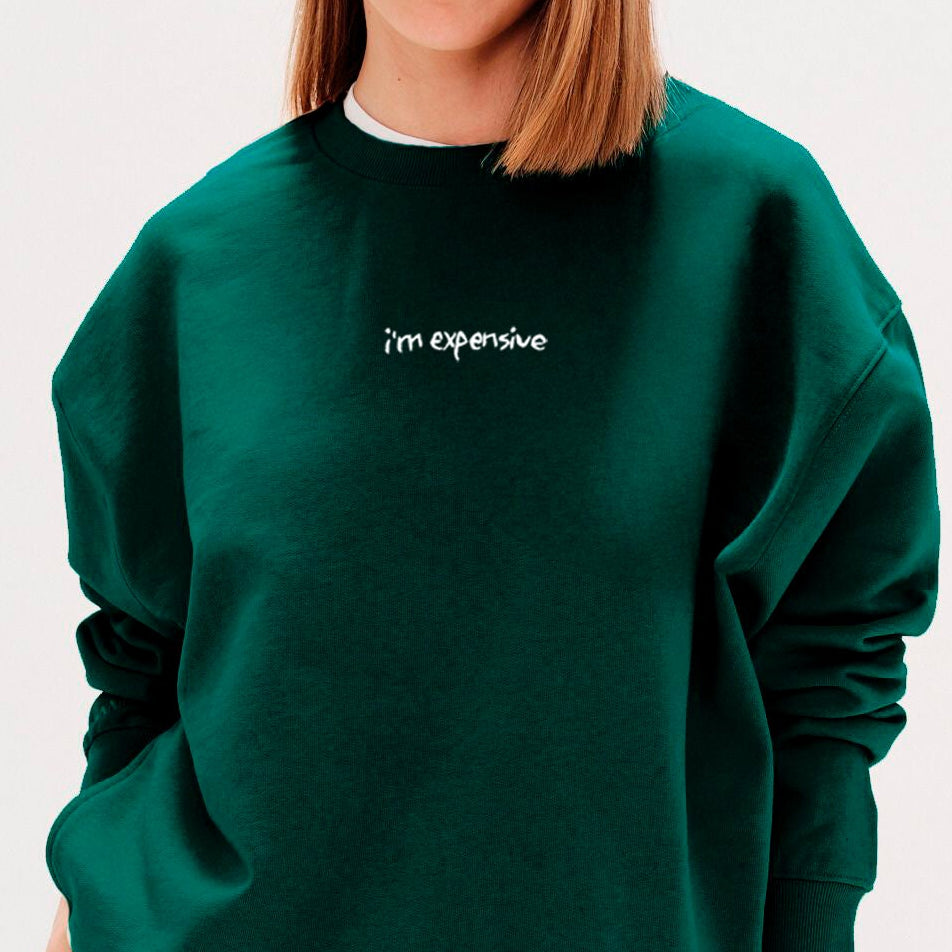 Woman wearing a green sweatshirt with an 'I'm expensive' embroidery