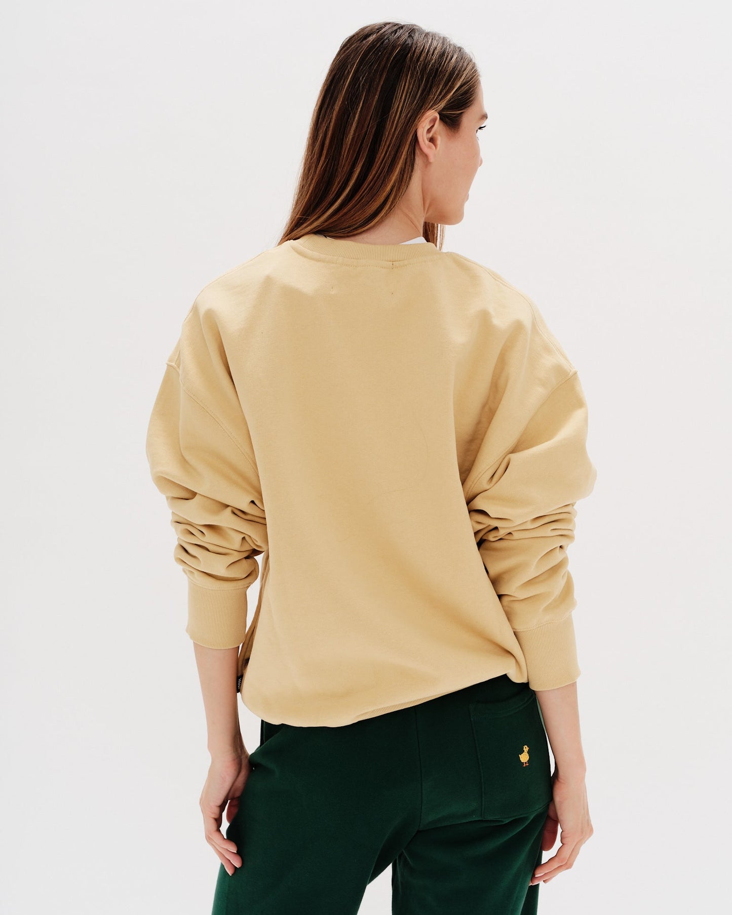 Woman wearing a yellow sweatshirt with a long hair wiener dog embroidery