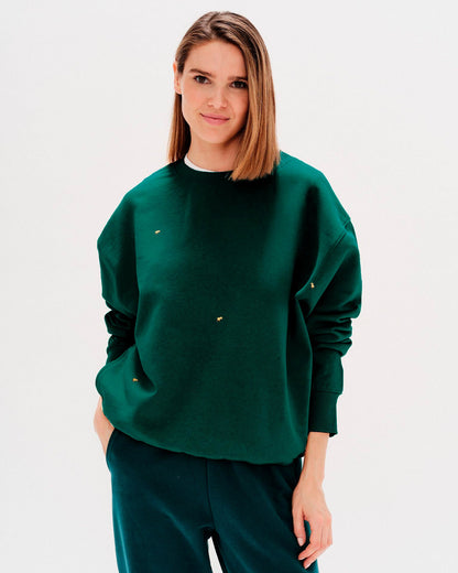 Woman wearing a green sweatshirt with ducks embroidery