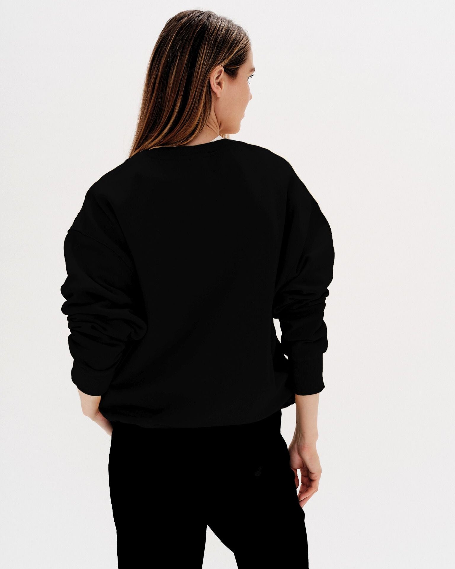 Woman wearing a black sweatshirt with a martini embroidery