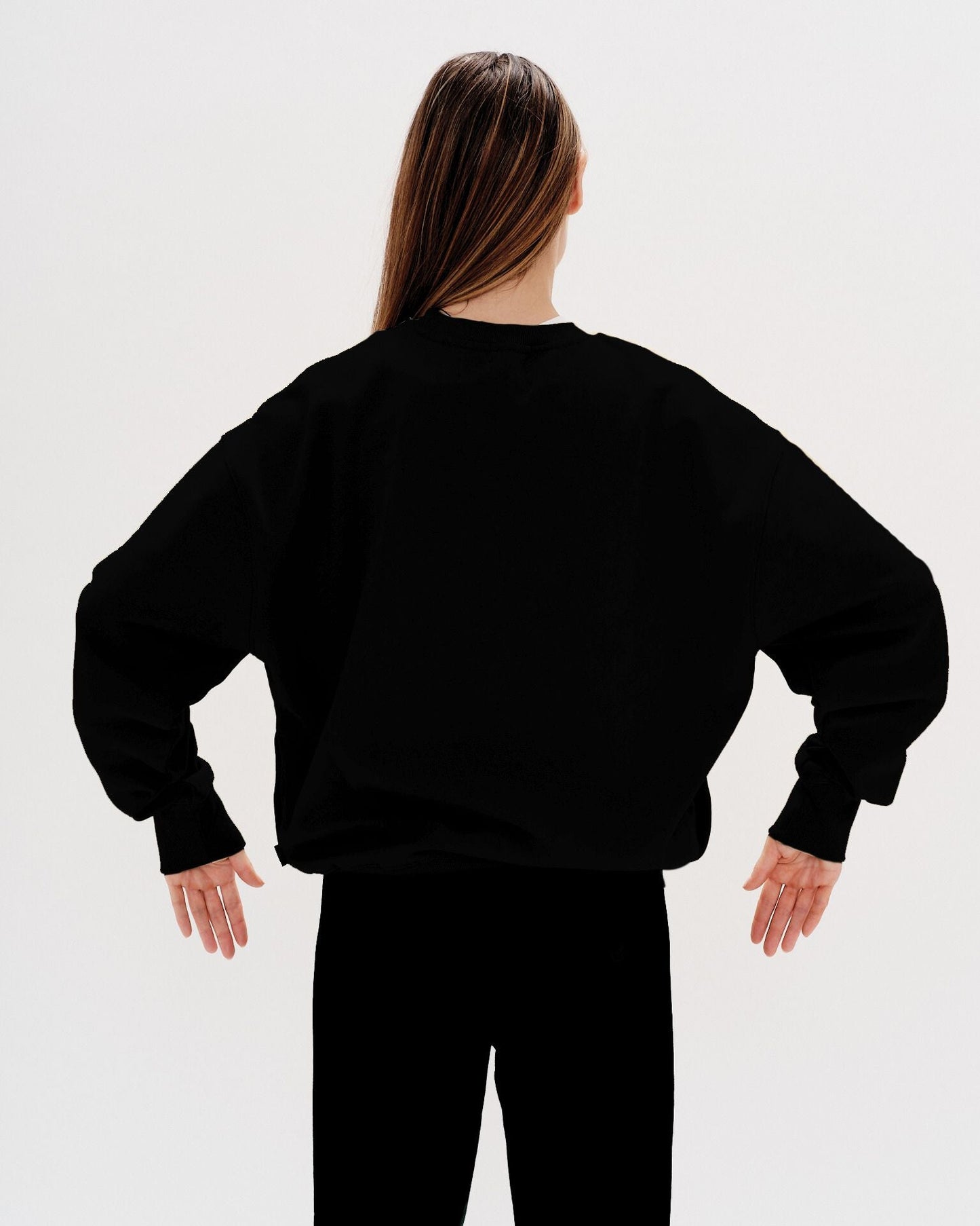 Woman wearing a black sweatshirt with a martini embroidery