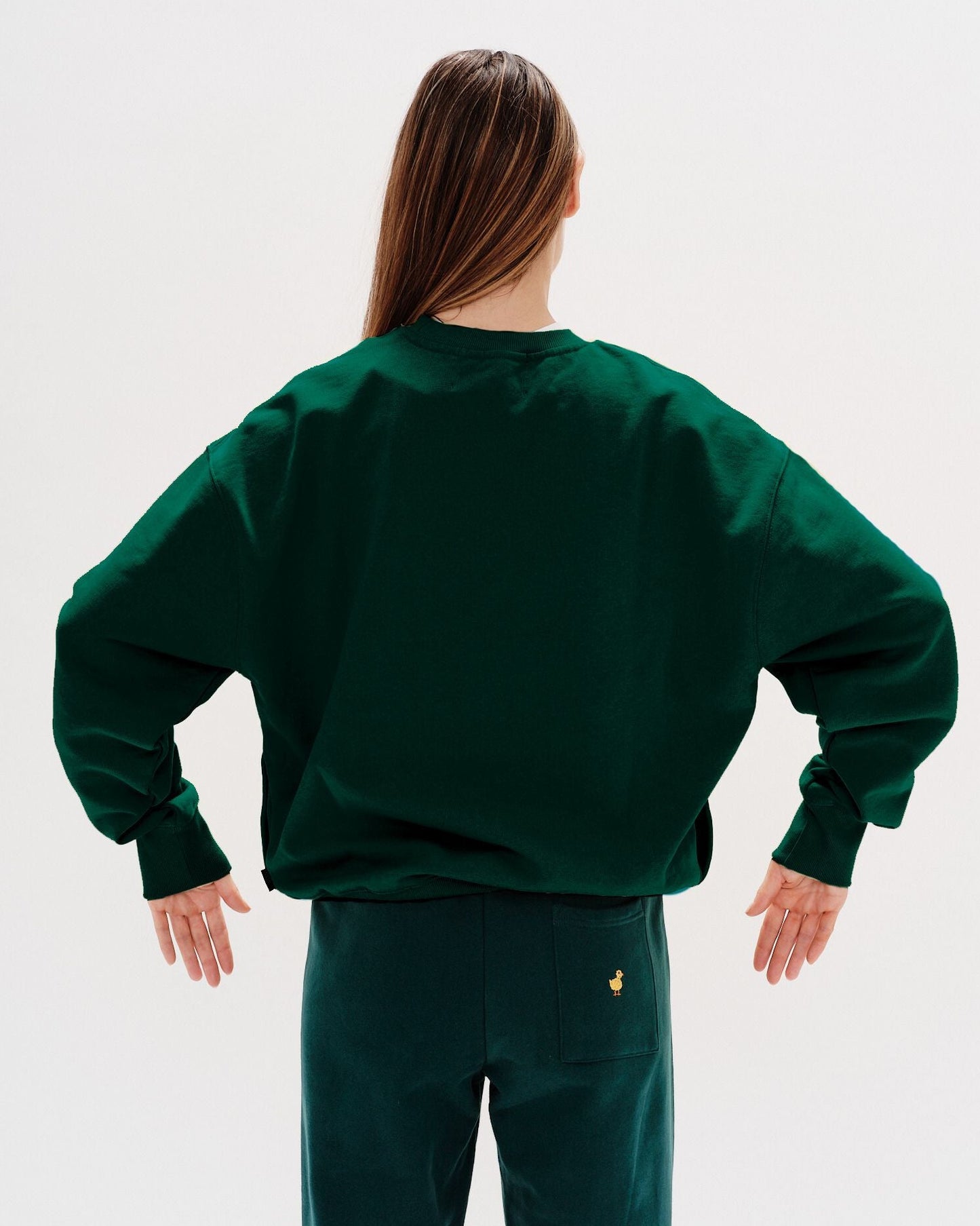 Woman wearing a green sweatshirt with New York Lover embroidered text