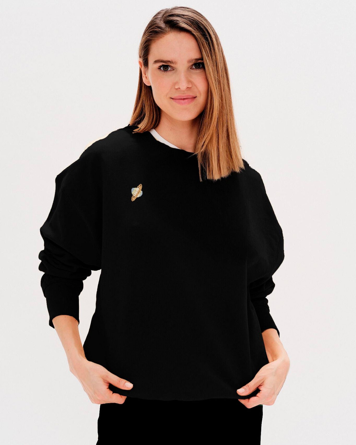 Woman wearing a black sweatshirt with a planet embroidery
