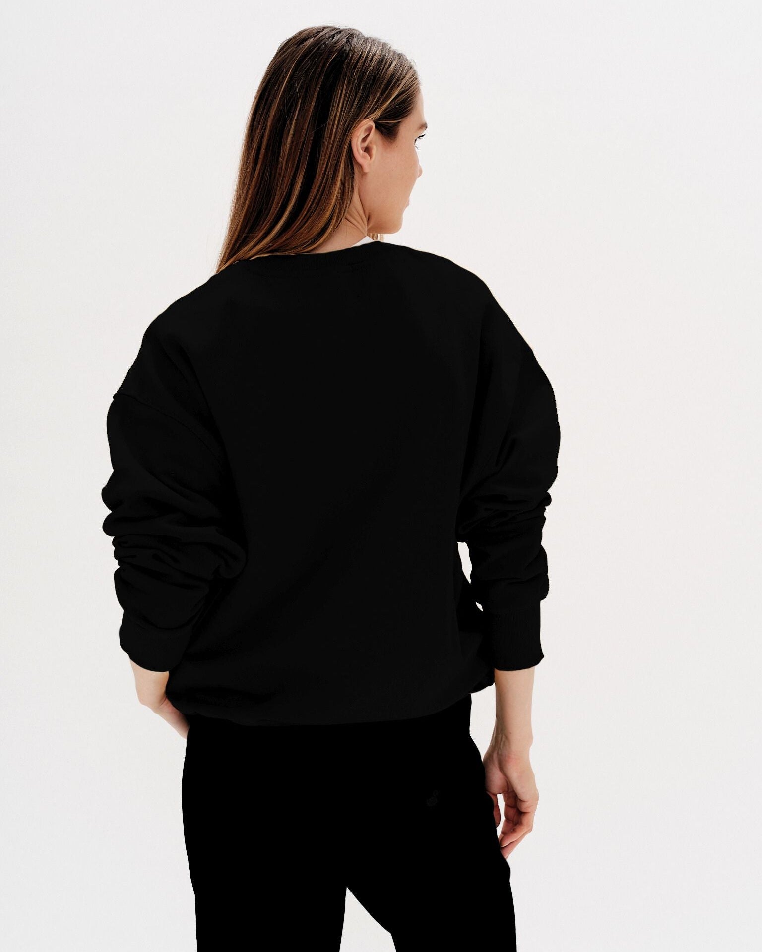 Woman wearing a black sweatshirt with a planet embroidery