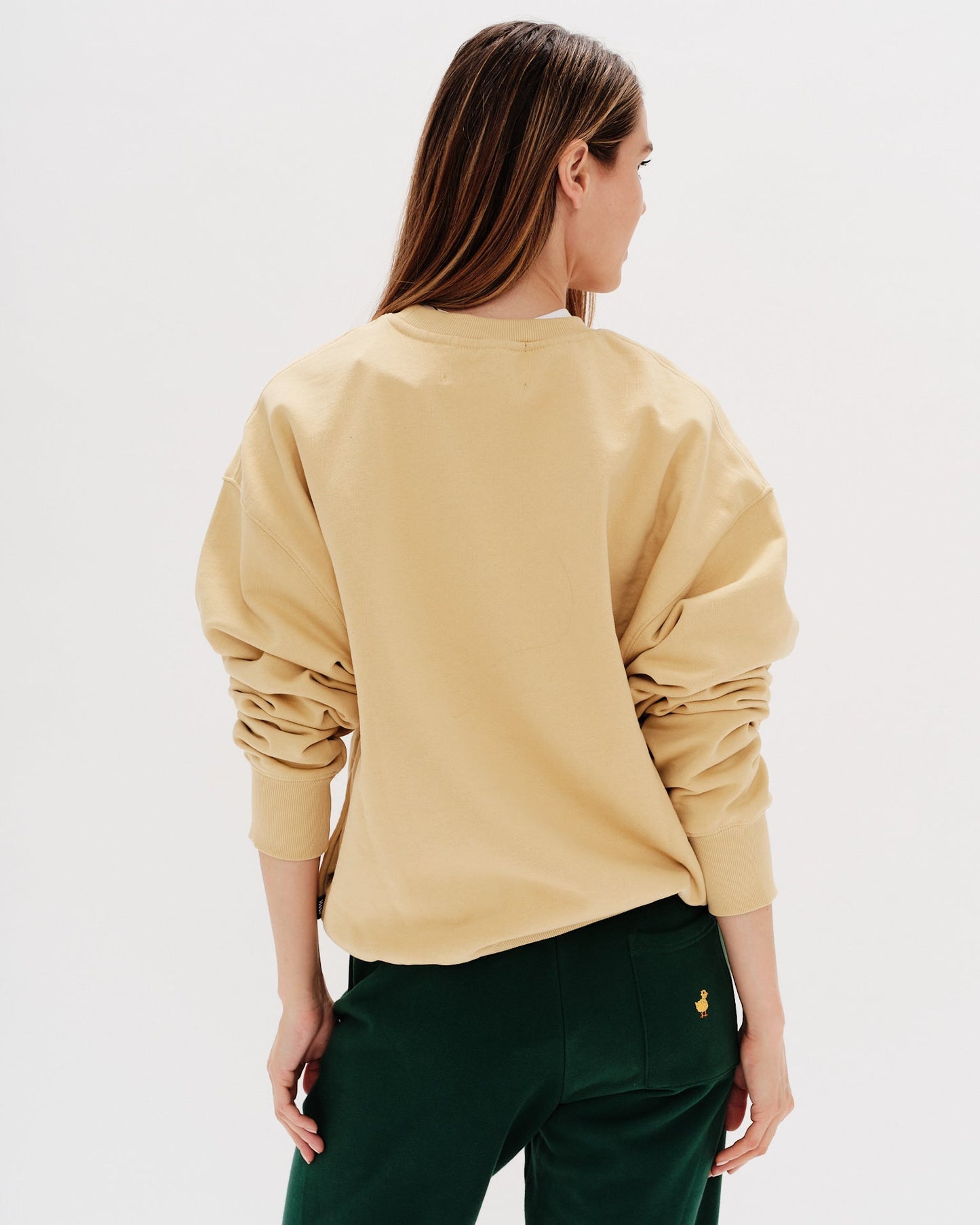 Woman wearing a yellow sweatshirt with a wiener dog embroidery