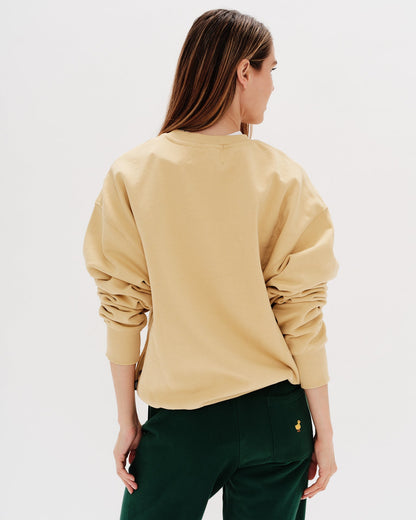 Woman wearing a yellow sweatshirt with a wiener dog embroidery