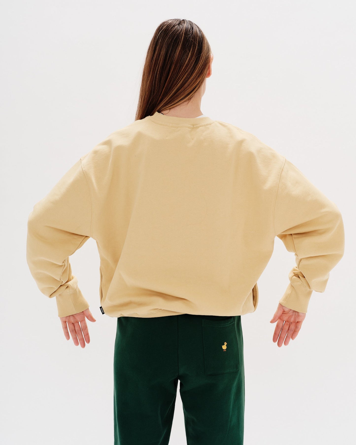 Woman wearing a yellow sweatshirt with a wiener dog embroidery
