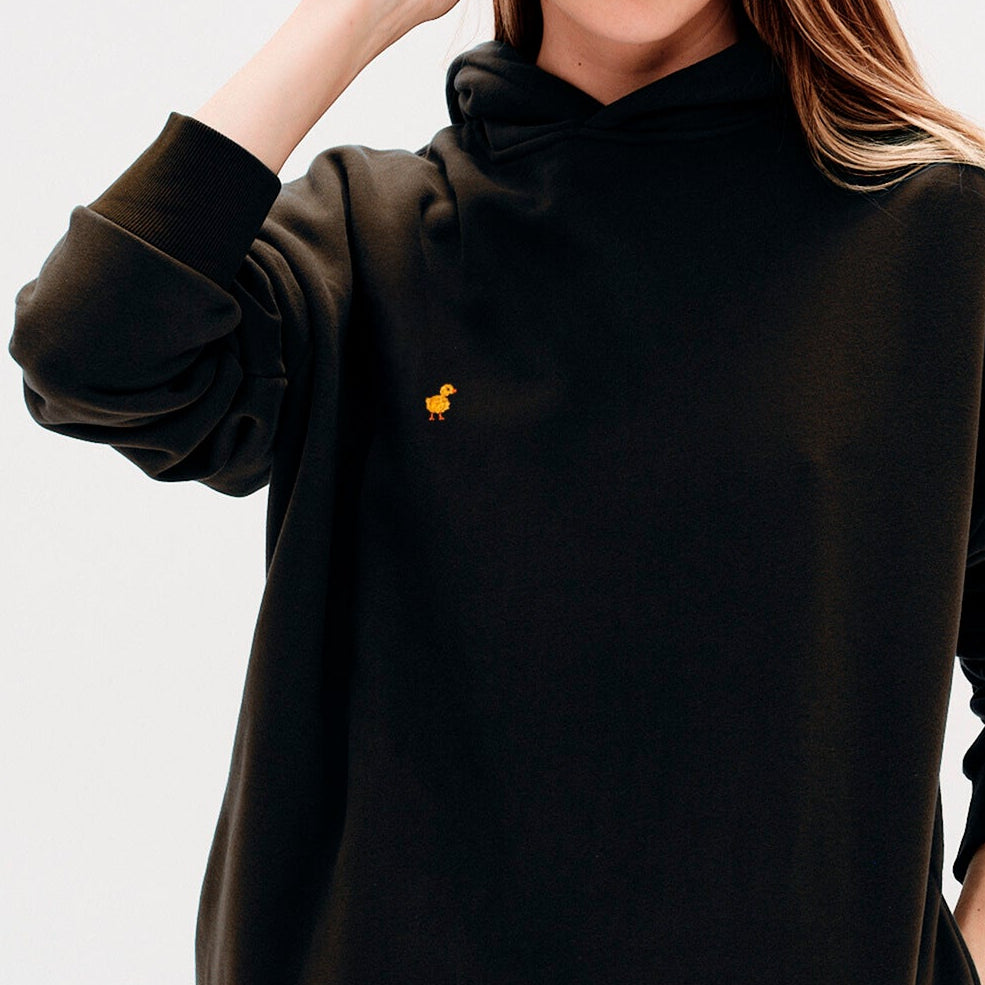 Woman wearing a premium black hoodie with a duck embroidery