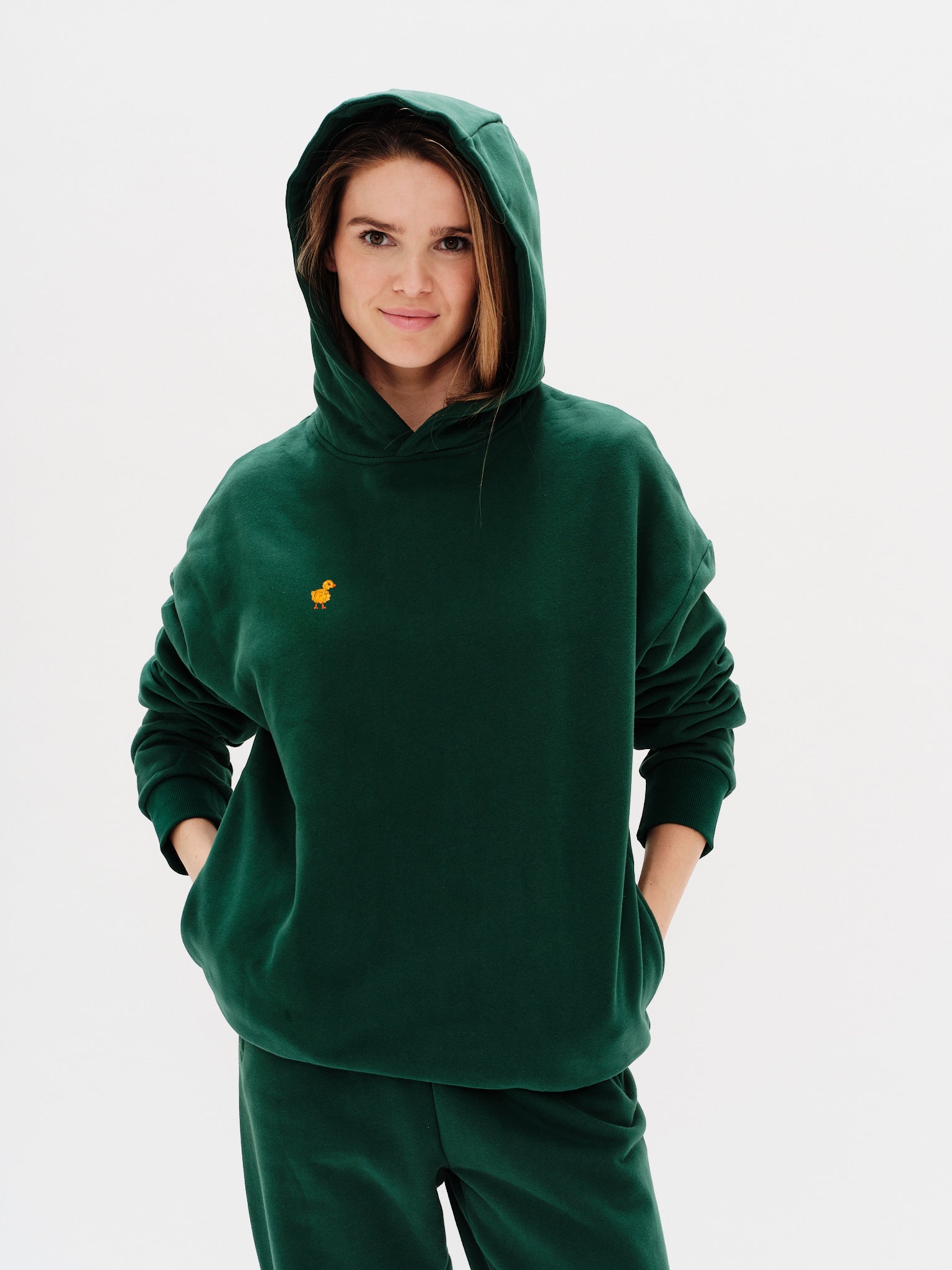 Woman wearing a premium green hoodie with a duck embroidery