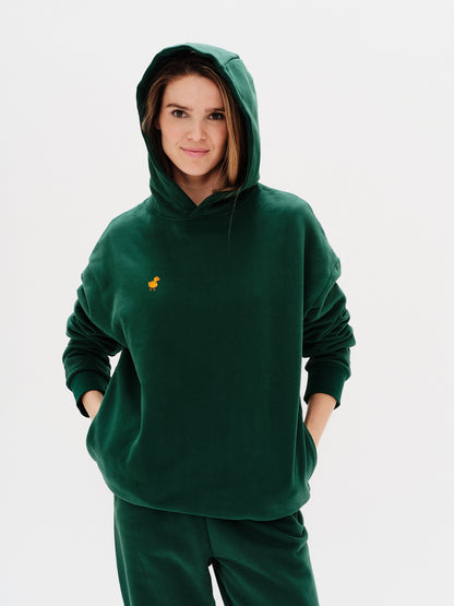 Woman wearing a premium green hoodie with a duck embroidery