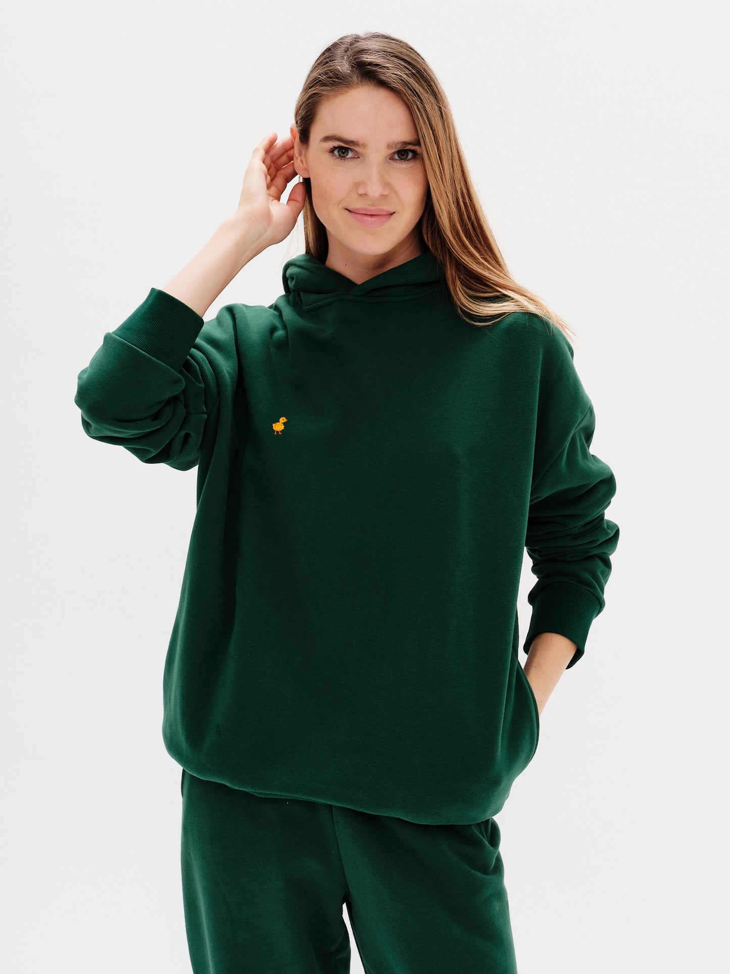 Woman wearing a premium green hoodie with a duck embroidery