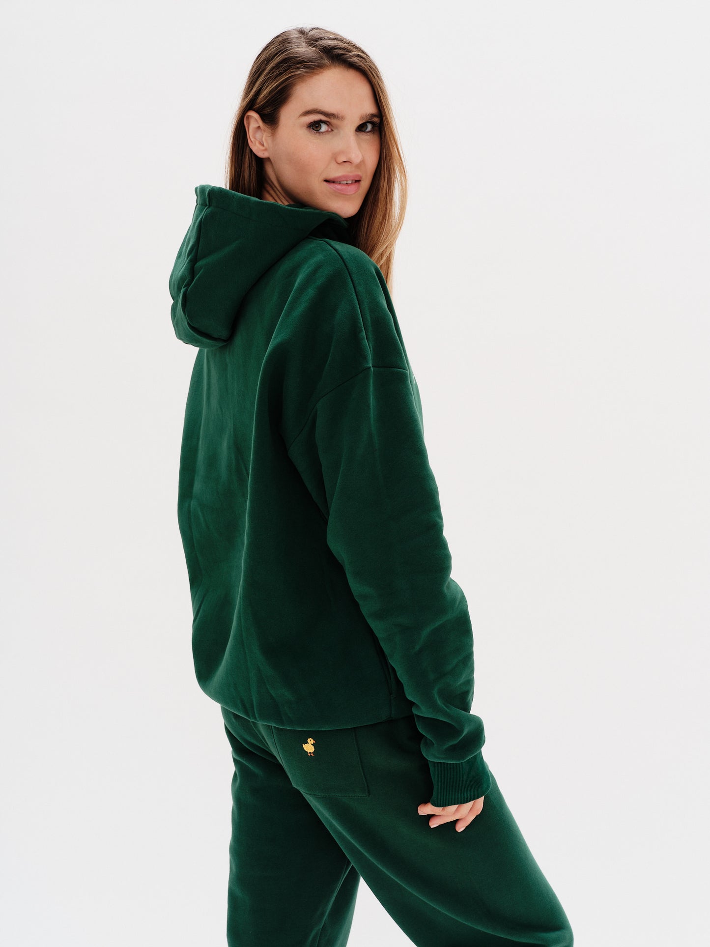 Woman wearing a premium green hoodie with a duck embroidery