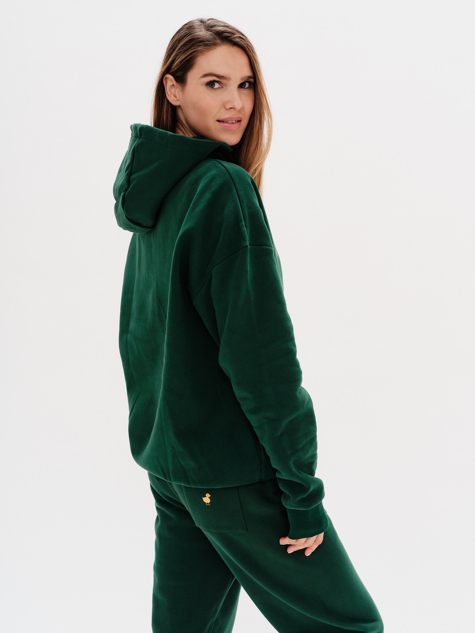 Woman wearing a premium green hoodie with a duck embroidery