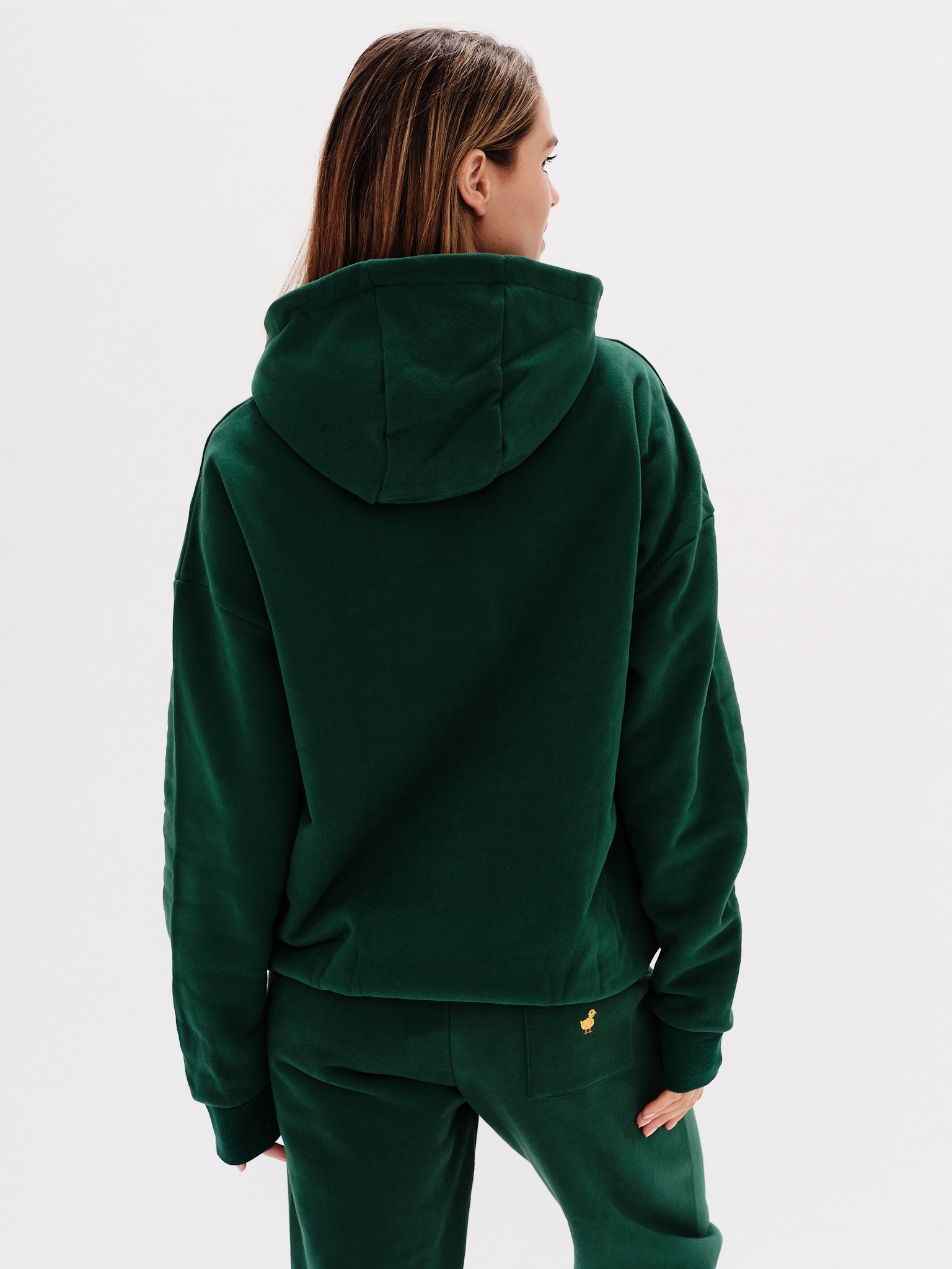 Woman wearing a premium green hoodie with a duck embroidery