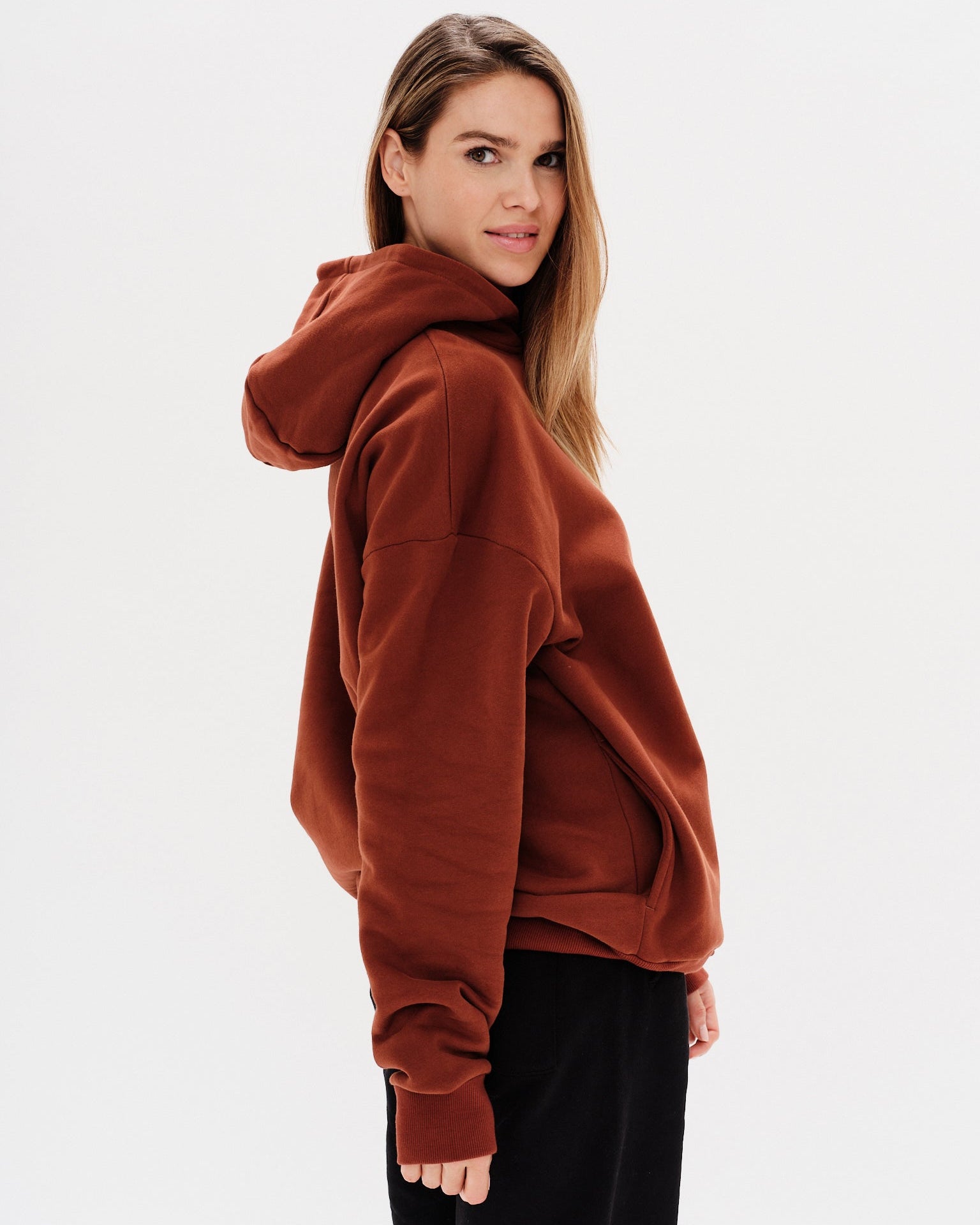 Woman wearing a brown hoodie with an I'm expensive embroidered text 