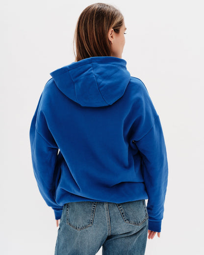 Woman wearing a blue sweatshirt with I don't want to work embroidery text