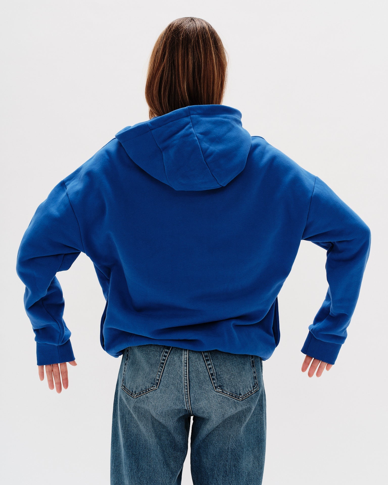 Woman wearing a blue sweatshirt with I don't want to work embroidery text
