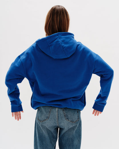 Woman wearing a blue hoodie with an I don't know what I want embroidery text