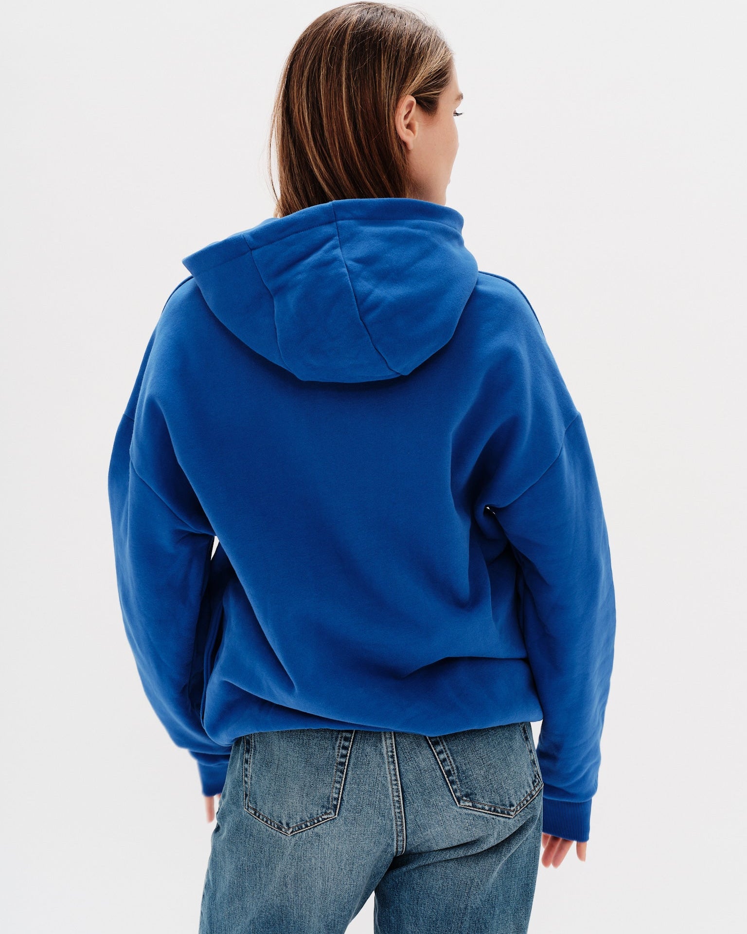 Woman wearing a blue hoodie with an I don't know what I want embroidery text