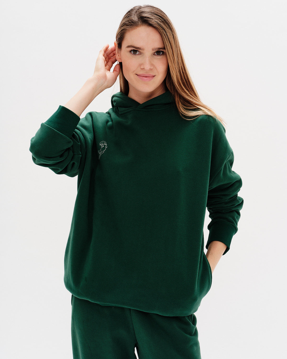 Woman wearing a green hoodie against a white background
