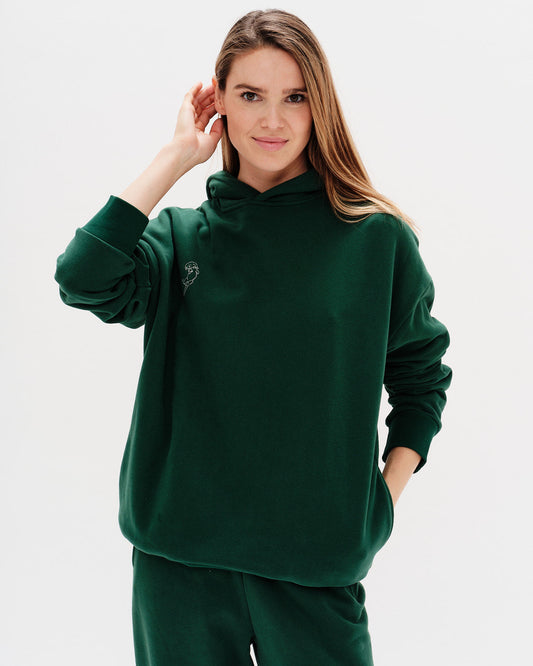 Woman wearing a green hoodie against a white background