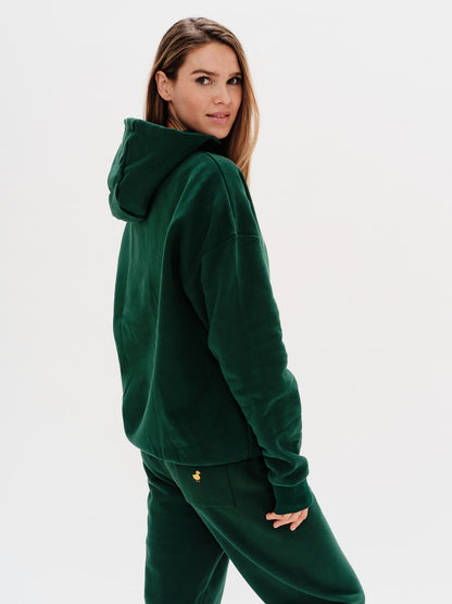Woman wearing a green hoodie on a white background