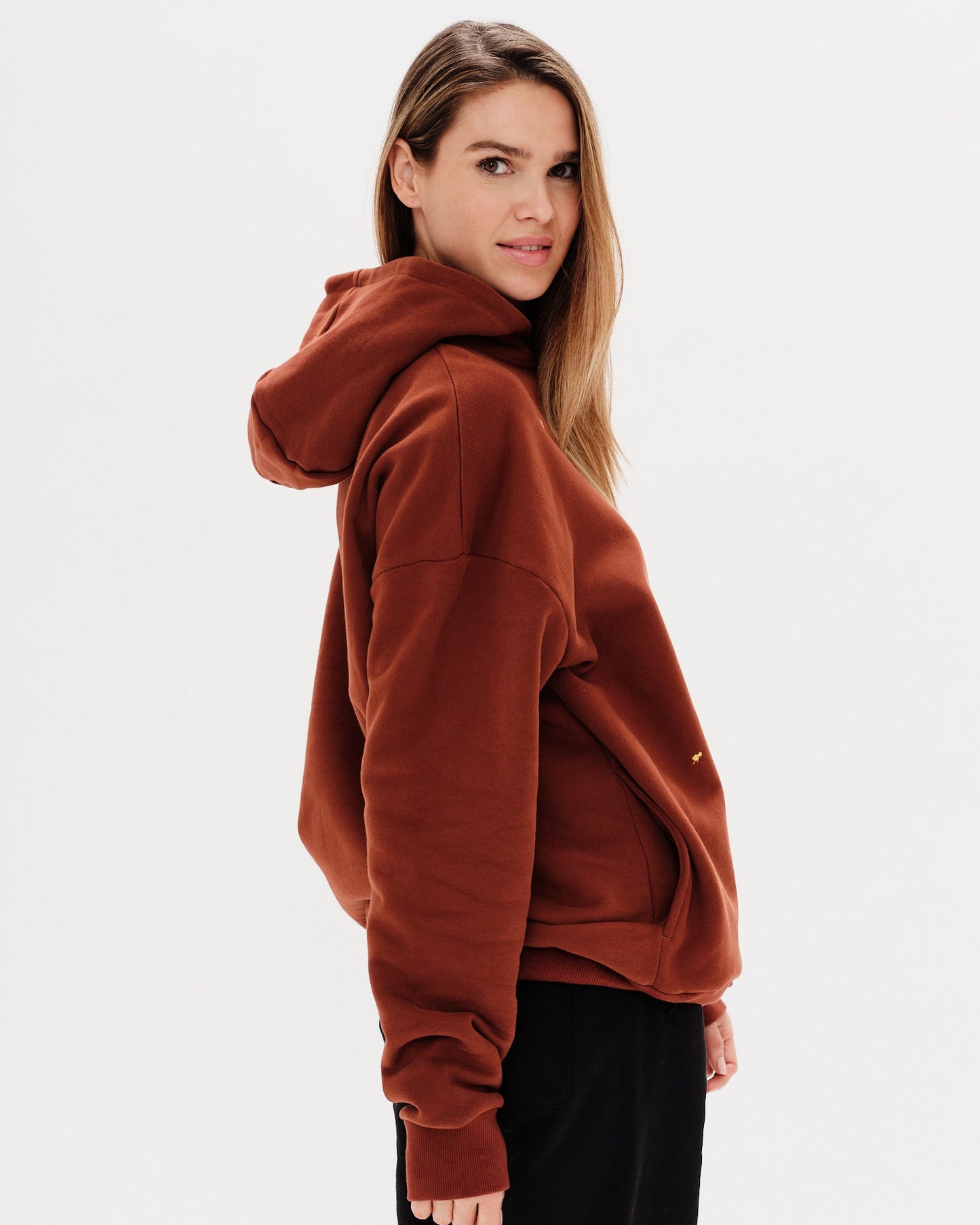 Woman wearing a brown premium hoodie with a mini duck embroidery