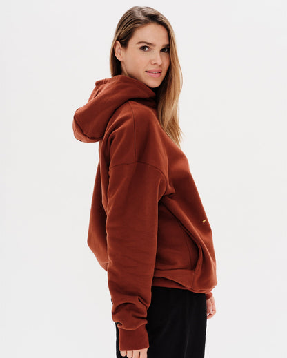 Woman wearing a brown premium hoodie with a mini duck embroidery