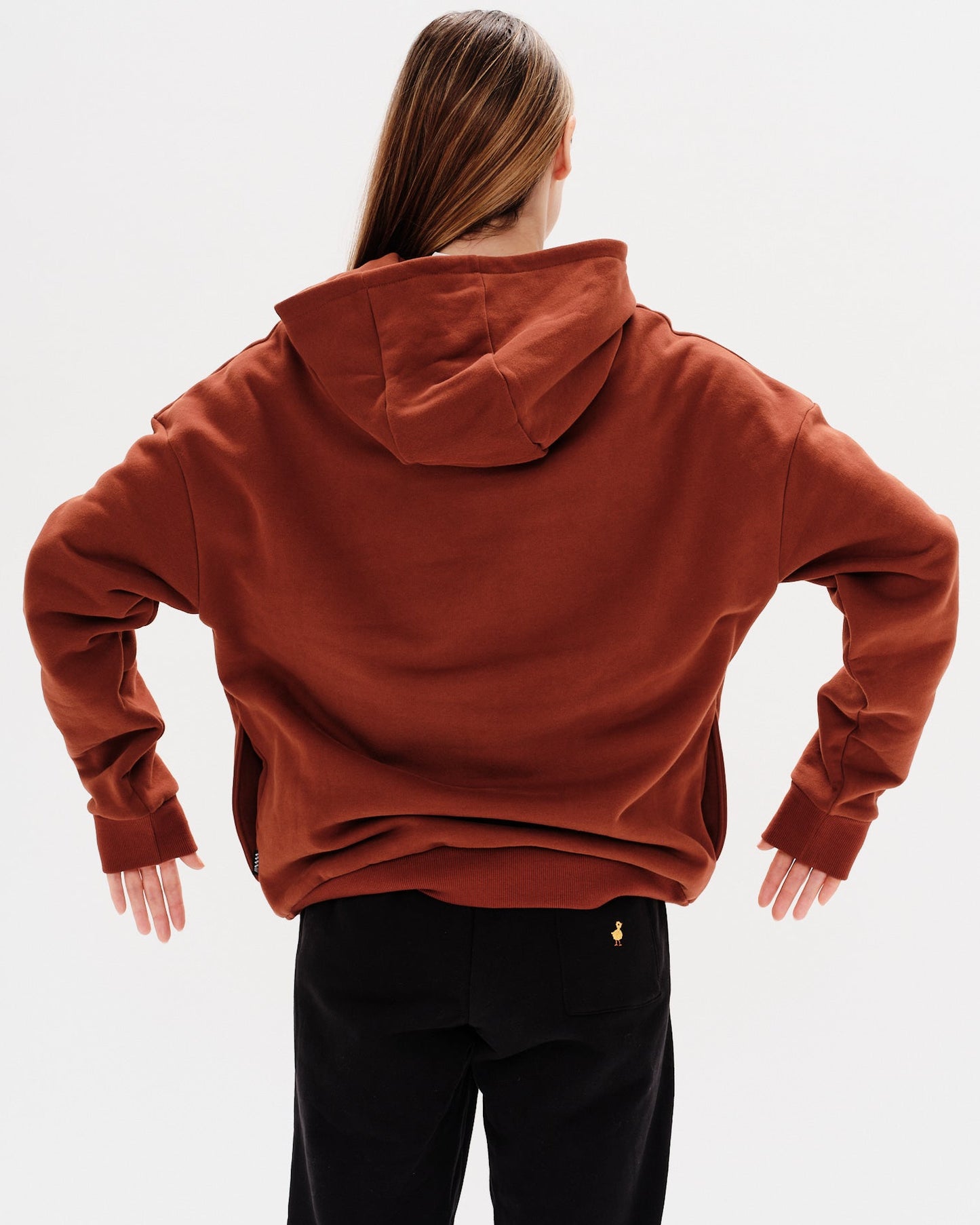 Woman wearing a brown premium hoodie with a mini duck embroidery