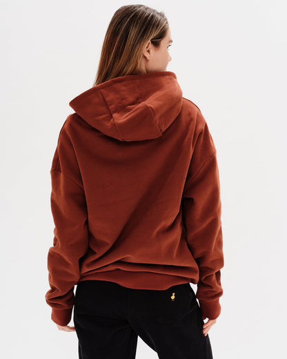 Woman wearing a brown premium hoodie with a mini duck embroidery