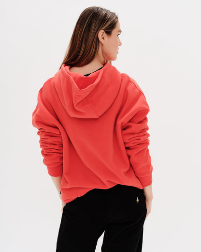 Woman wearing an orange hoodie with a New York Girl embroidery.