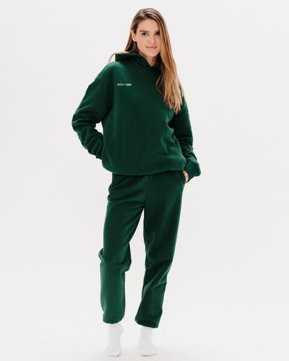 Woman wearing a green premium hoodie with a 'New York' embroidery