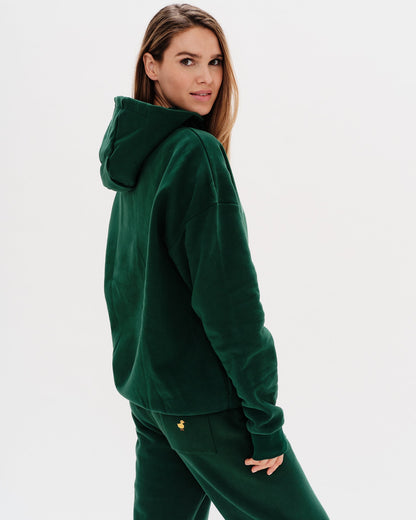 Woman wearing a green premium hoodie with a 'New York' embroidery