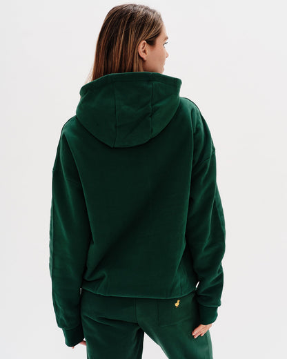 Woman wearing a green premium hoodie with a 'New York' embroidery