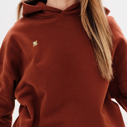 Woman wearing a premium black hoodie with a planet embroidery