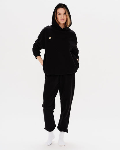 Woman wearing a premium black hoodie with a planet embroidery