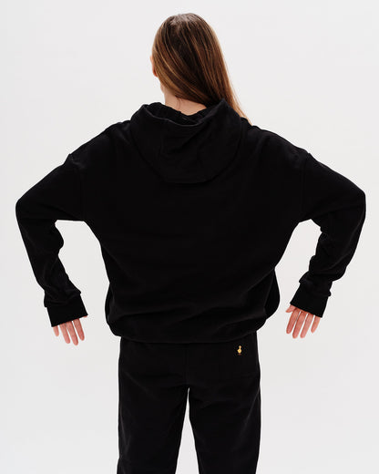 Woman wearing a premium black hoodie with a planet embroidery